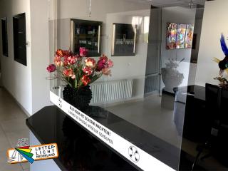 Hangend glashelder plexiglas scherm beplakt met stickerfolie